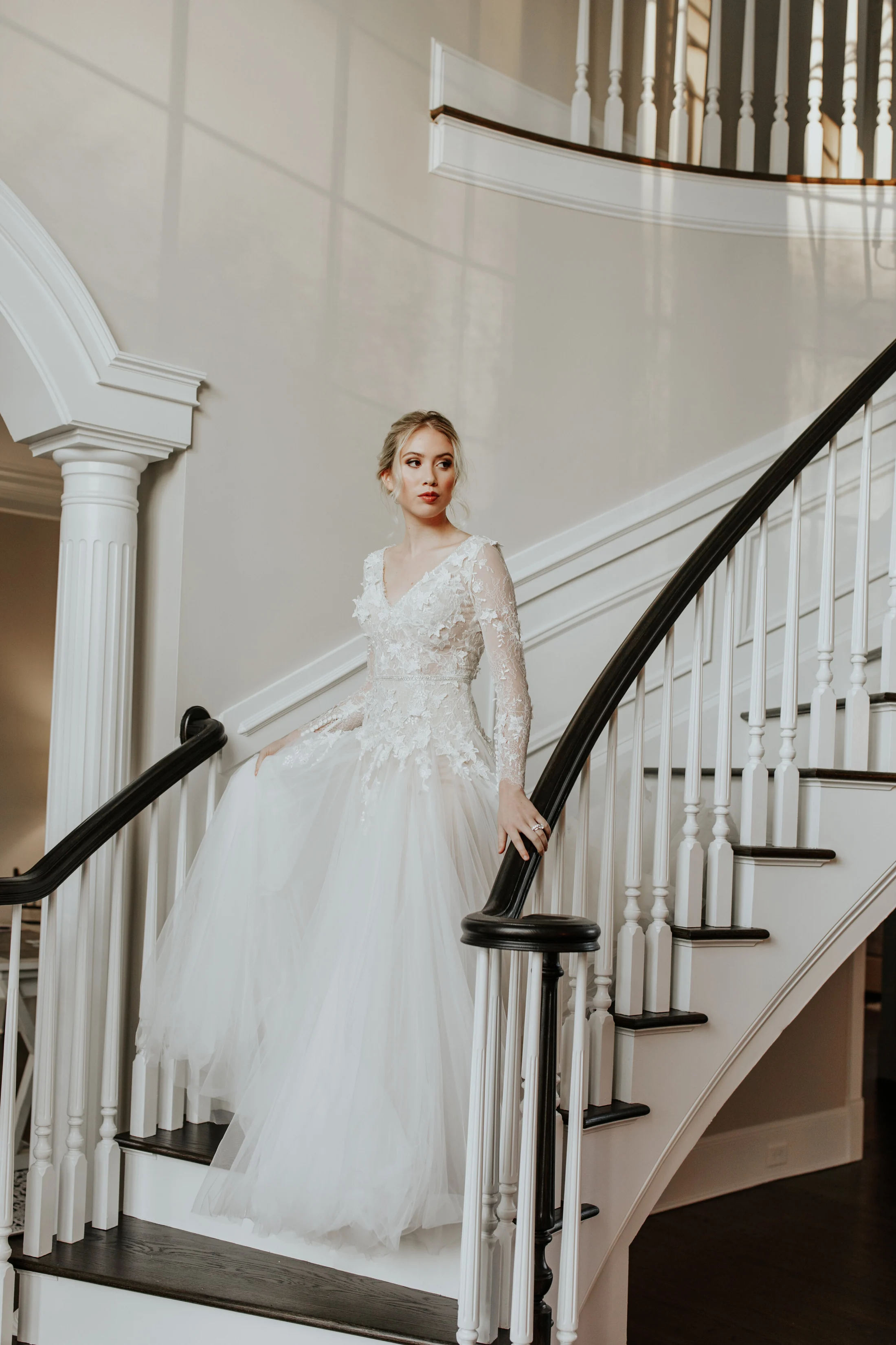 A bride on the mansion's grand staircase