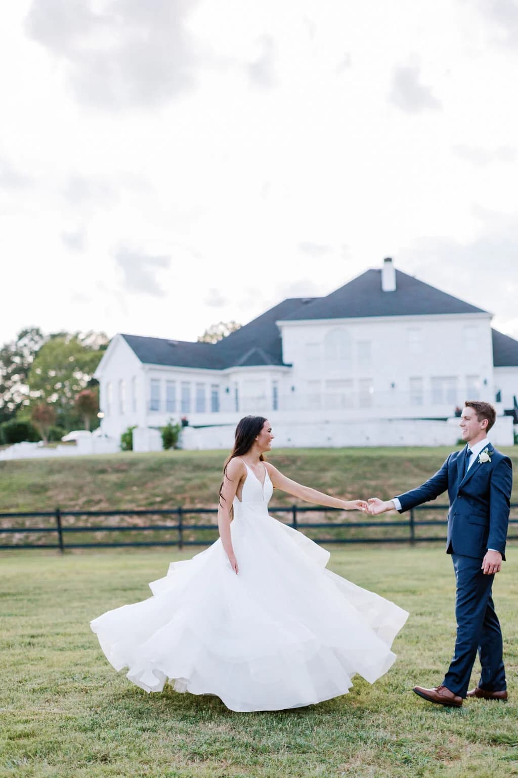 A couple dancing on the lawn with the mansion behind them