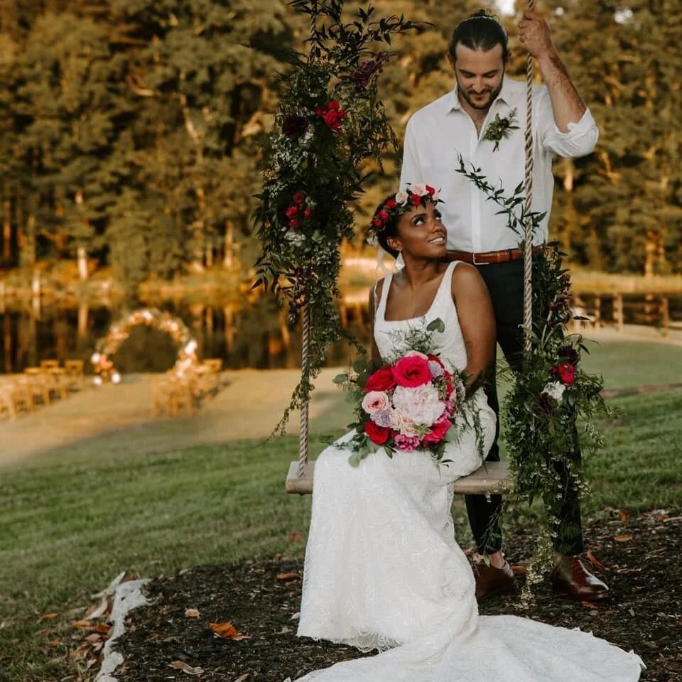 A couple on the flower-draped swing beneath the oaks