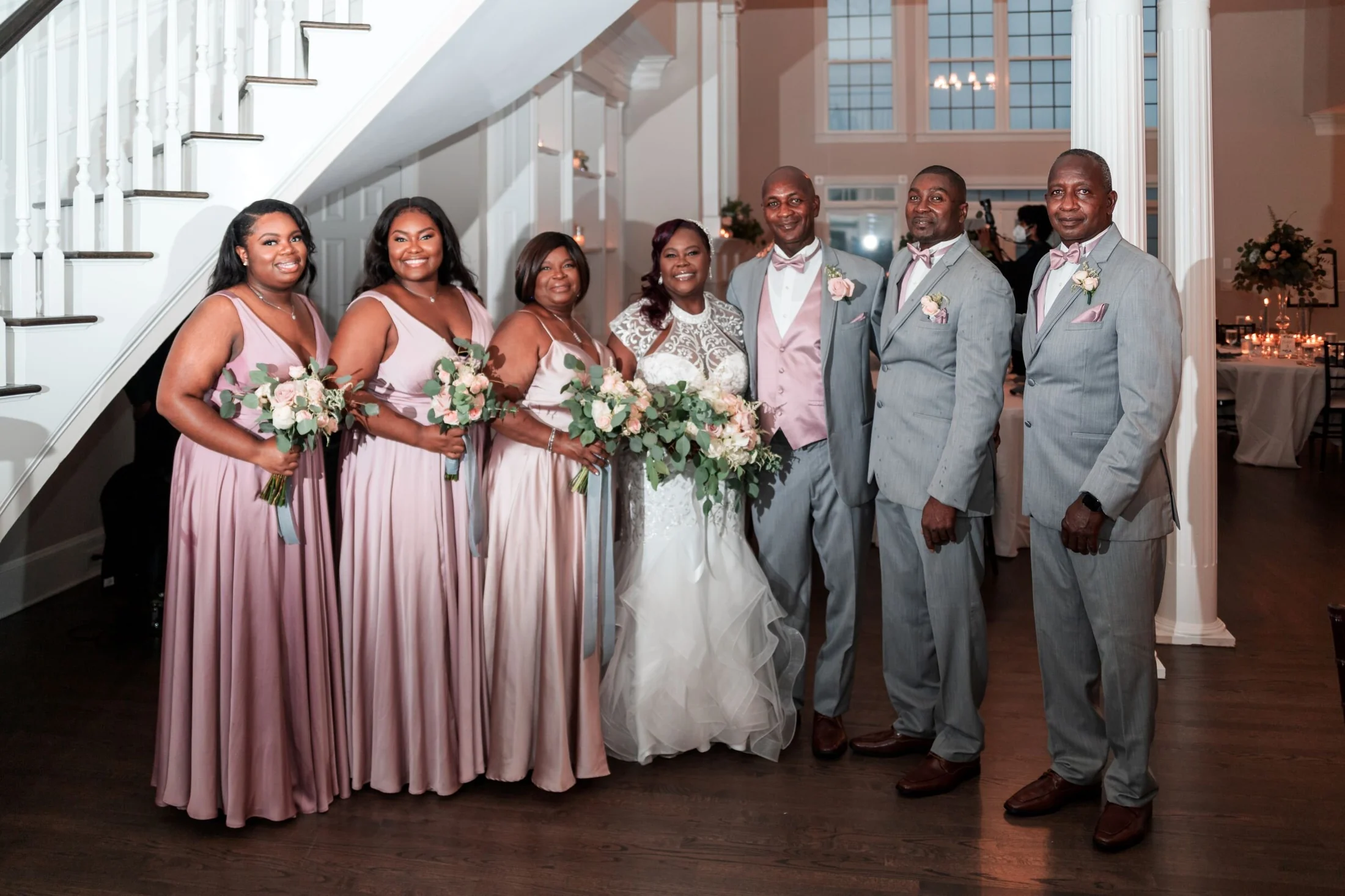 The full wedding party in the mansion foyer